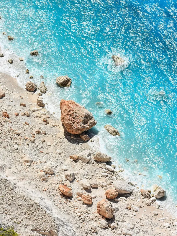 A rocky beach with a body of water in the background