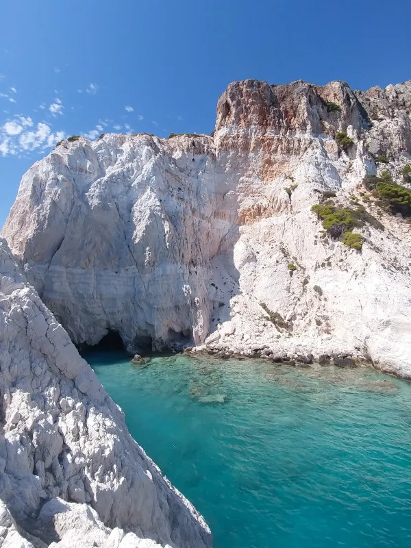 White rocky mountain beside blue sea